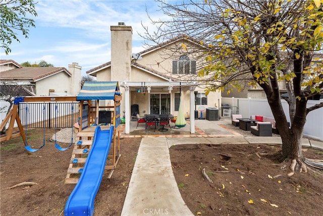 rear view of house featuring a playground, an outdoor hangout area, and a patio area