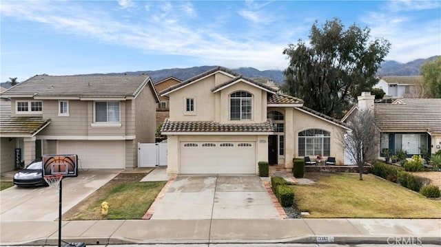 view of front facade featuring a garage, a mountain view, and a front yard