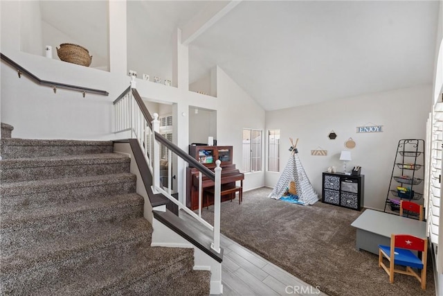 stairway featuring hardwood / wood-style flooring and high vaulted ceiling