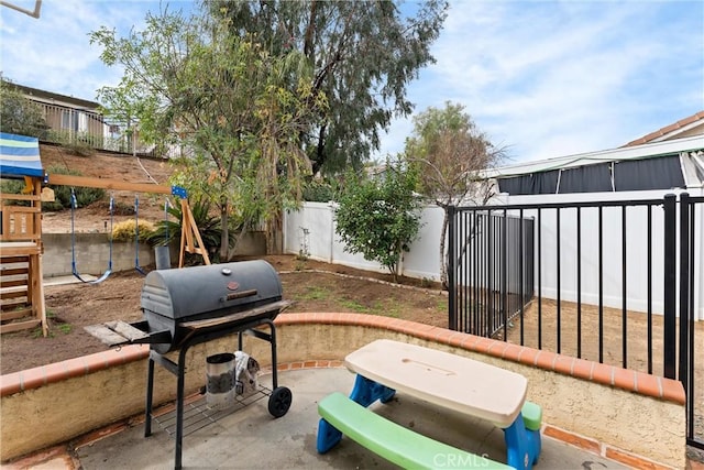 view of patio with a playground and area for grilling