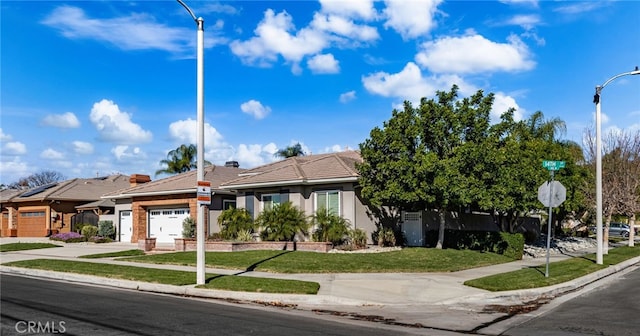 view of front of house featuring a garage and a front lawn