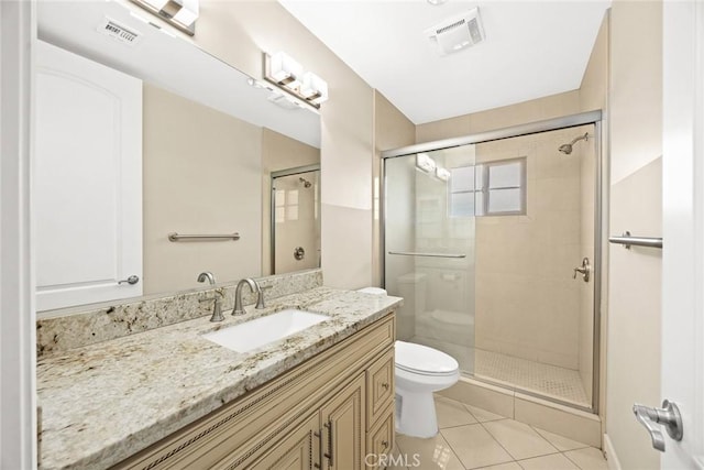 bathroom with vanity, toilet, a shower with door, and tile patterned flooring