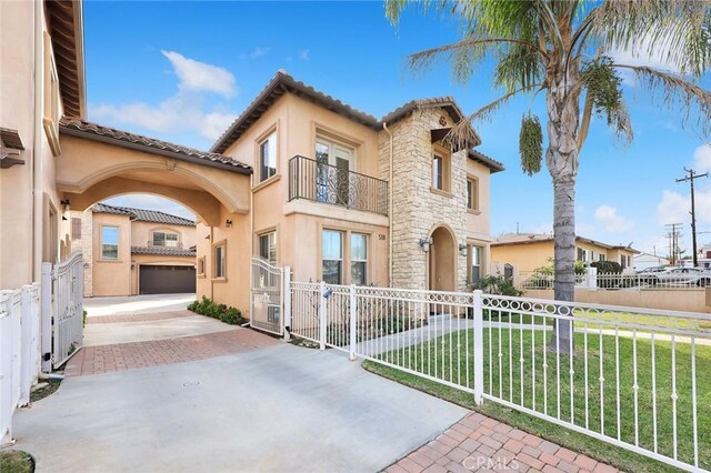 518 W Bencamp St, San Gabriel, CA 91776 - mediterranean / spanish house featuring a balcony, driveway, stucco siding, and a gate