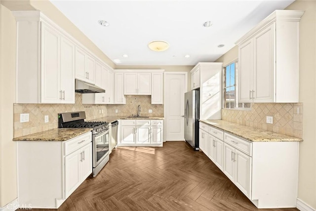 kitchen with white cabinetry, dark parquet flooring, light stone countertops, and appliances with stainless steel finishes