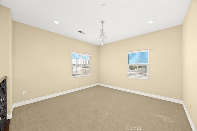 spare room with an inviting chandelier and carpet floors