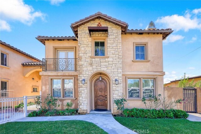 518 W Bencamp St, San Gabriel, CA 91776 - mediterranean / spanish-style home with stone siding, stucco siding, a balcony, a gate, and a tiled roof