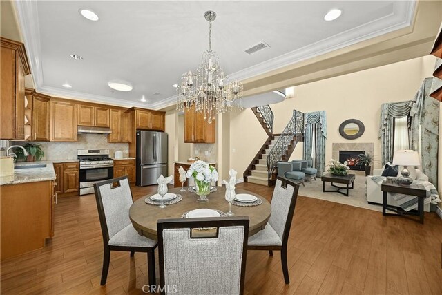 518 W Bencamp St, San Gabriel, CA 91776 - dining room with stairway, wood finished floors, crown molding, a chandelier, and a premium fireplace