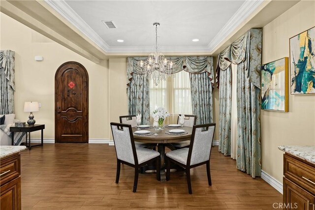 518 W Bencamp St, San Gabriel, CA 91776 - dining space featuring crown molding, a chandelier, dark wood-type flooring, arched walkways, and baseboards