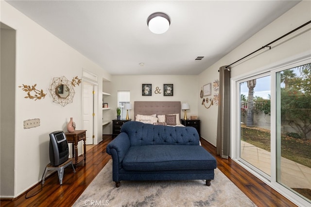 bedroom with access to exterior, dark hardwood / wood-style flooring, and multiple windows