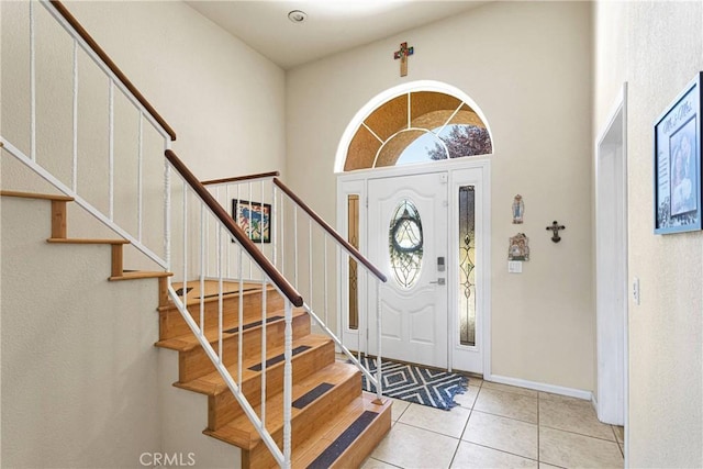 tiled foyer with a towering ceiling