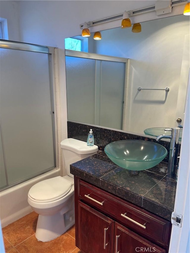 full bathroom with tile patterned flooring, vanity, enclosed tub / shower combo, and toilet