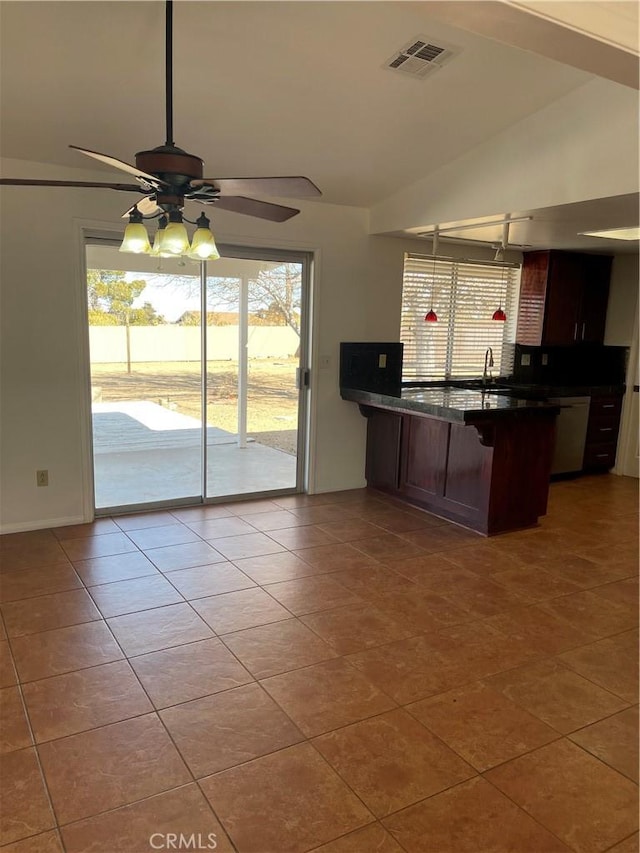 kitchen with light tile patterned flooring, lofted ceiling, a kitchen bar, sink, and ceiling fan