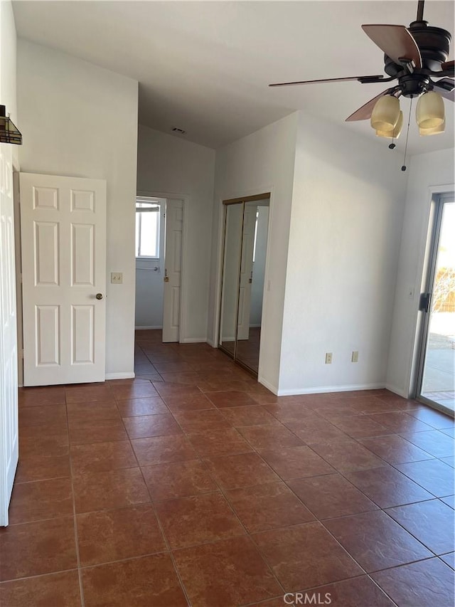 tiled spare room featuring a wealth of natural light and ceiling fan