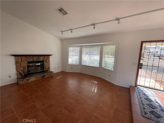 unfurnished living room featuring dark tile patterned floors, rail lighting, and a fireplace