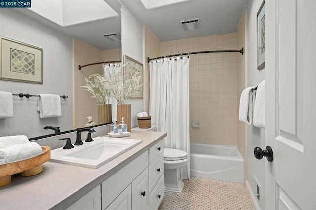 full bathroom featuring shower / tub combo, a skylight, vanity, tile patterned floors, and toilet