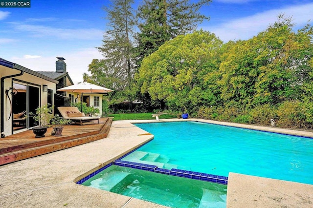 view of swimming pool featuring a wooden deck and an in ground hot tub