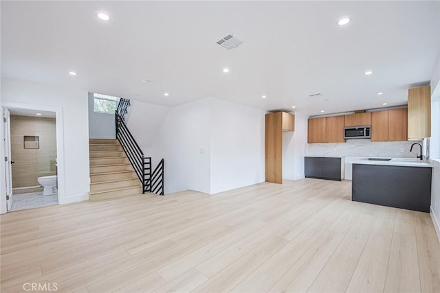 interior space featuring sink, backsplash, and light hardwood / wood-style floors