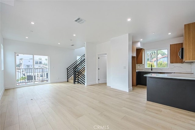 kitchen with sink, decorative backsplash, and light wood-type flooring