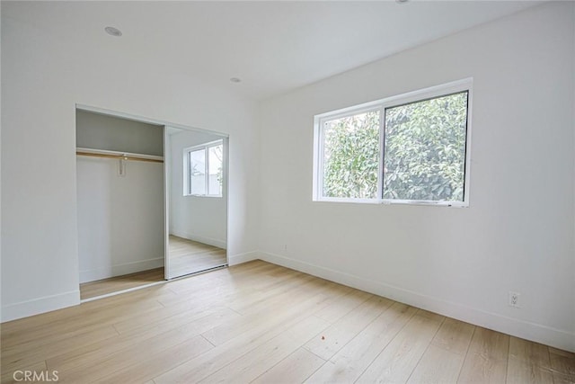 unfurnished bedroom featuring light hardwood / wood-style floors and a closet