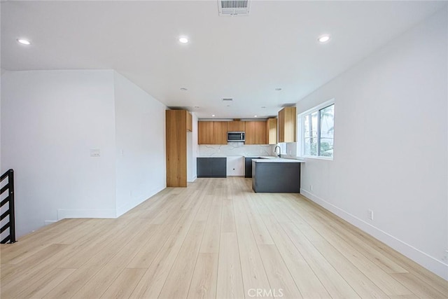 kitchen featuring sink, backsplash, and light hardwood / wood-style flooring