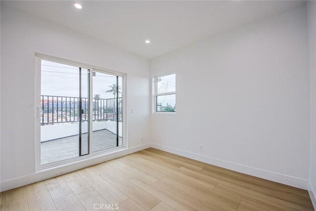 empty room with light hardwood / wood-style flooring and plenty of natural light