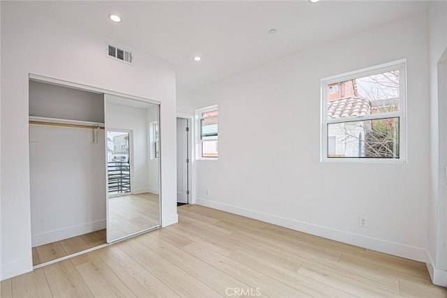 unfurnished bedroom featuring a closet and light wood-type flooring