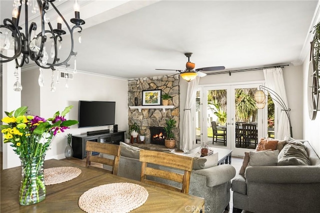 living room featuring crown molding, a stone fireplace, ceiling fan, and french doors