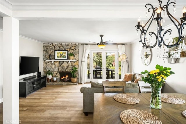 living room featuring crown molding, hardwood / wood-style floors, a fireplace, and french doors