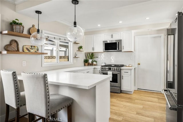 kitchen with white cabinets, a kitchen breakfast bar, kitchen peninsula, and high quality appliances