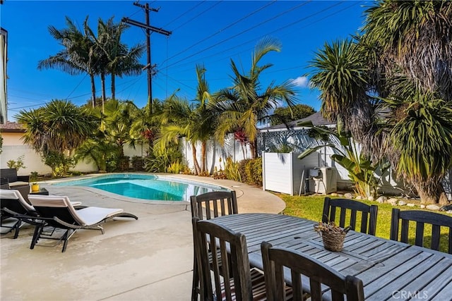 view of swimming pool with a shed and a patio area