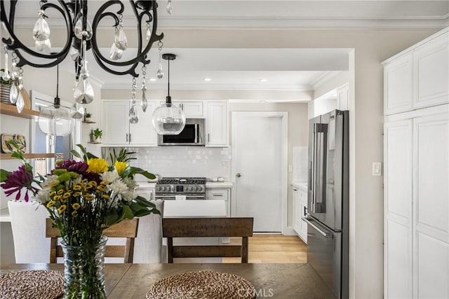 kitchen featuring tasteful backsplash, stainless steel appliances, crown molding, and white cabinets