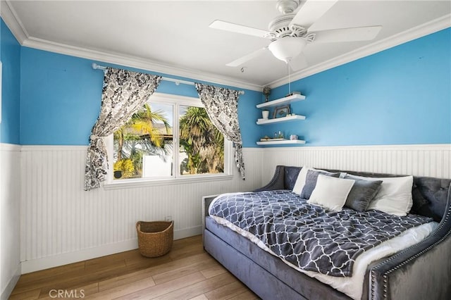 bedroom featuring hardwood / wood-style floors, ornamental molding, and ceiling fan