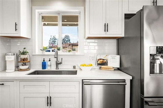 bar featuring tasteful backsplash, white cabinetry, appliances with stainless steel finishes, and sink