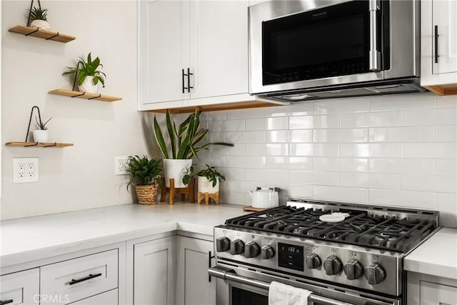 kitchen featuring tasteful backsplash, appliances with stainless steel finishes, and white cabinets