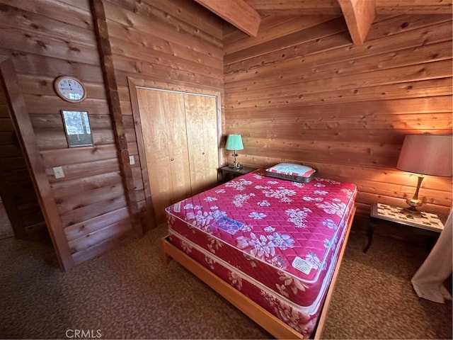 bedroom featuring carpet, beam ceiling, and wood walls