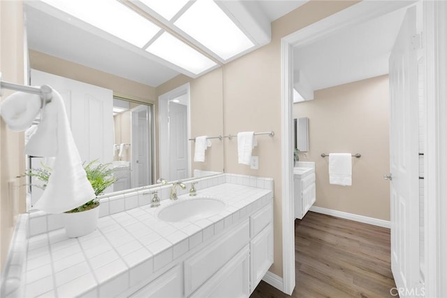 bathroom with vanity, hardwood / wood-style flooring, and a skylight