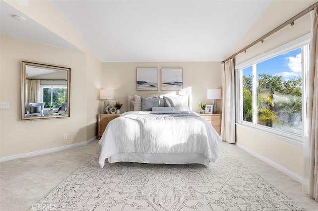 bedroom with lofted ceiling and light colored carpet