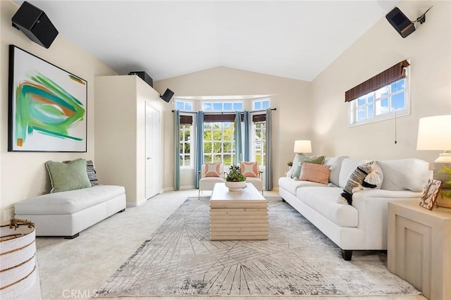 living room with vaulted ceiling, a healthy amount of sunlight, and light carpet