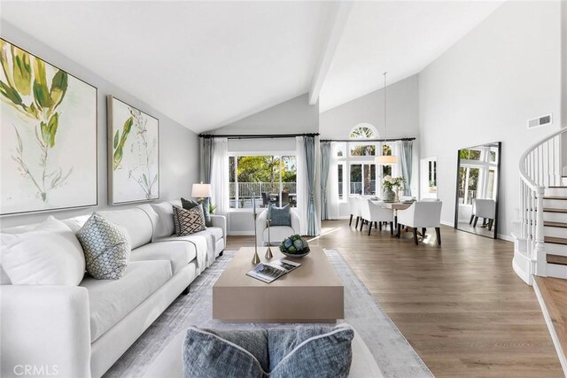 living room with wood-type flooring and high vaulted ceiling