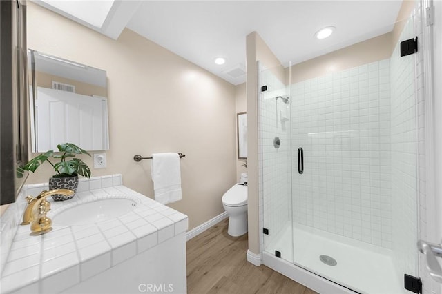 bathroom with walk in shower, vanity, toilet, and hardwood / wood-style floors