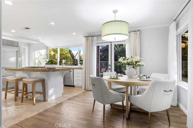 dining room with crown molding and light wood-type flooring