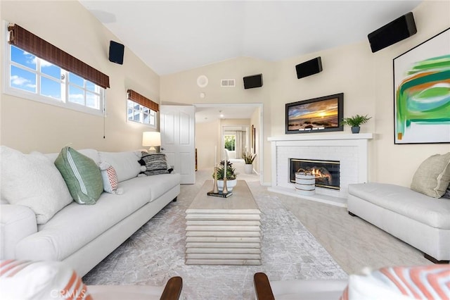 carpeted living room featuring a brick fireplace, a wealth of natural light, and vaulted ceiling