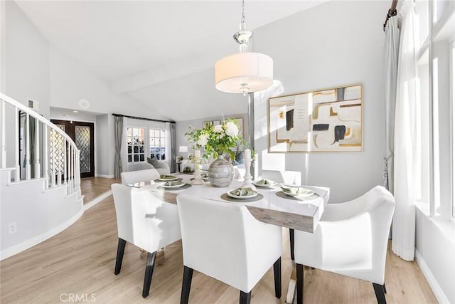 dining space with vaulted ceiling and light wood-type flooring