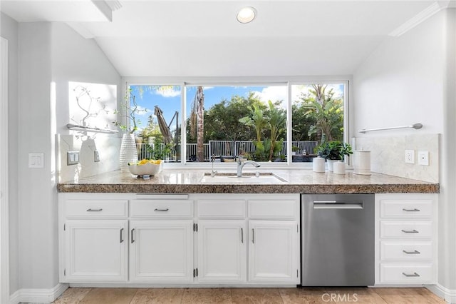 kitchen featuring white cabinetry, lofted ceiling, and sink