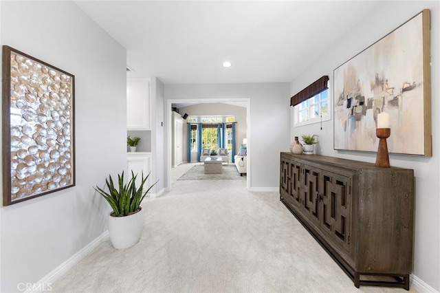 hallway with plenty of natural light and light carpet