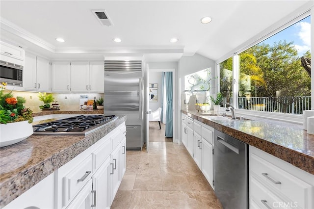 kitchen with white cabinetry, sink, and built in appliances