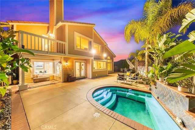 pool at dusk with a patio