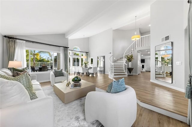 living room with high vaulted ceiling and light wood-type flooring