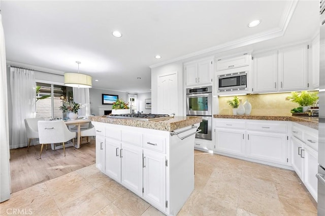 kitchen featuring white cabinetry, hanging light fixtures, and appliances with stainless steel finishes