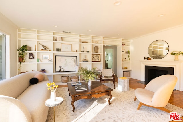 living room featuring hardwood / wood-style flooring and crown molding